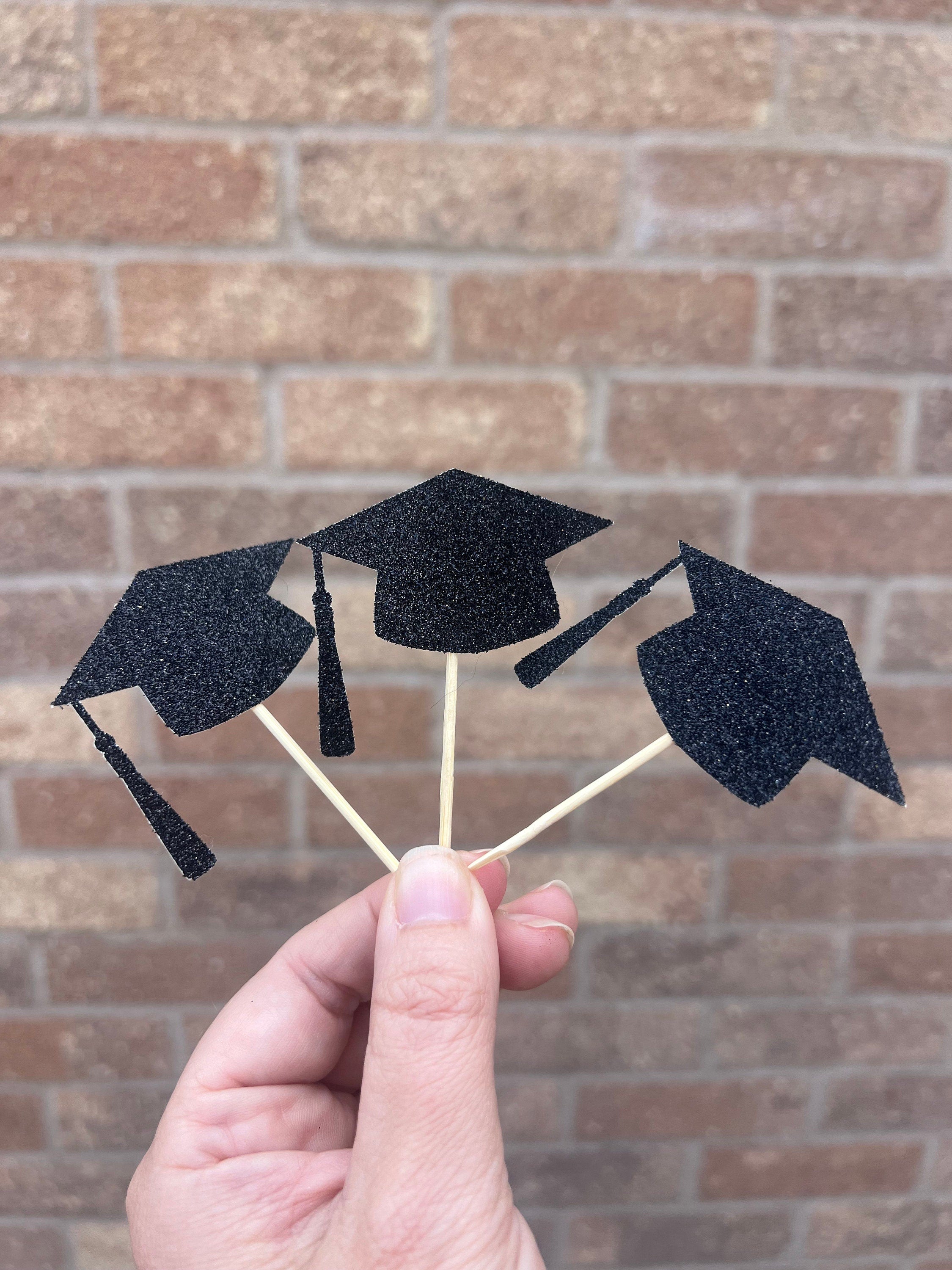 black glitter graduation cap cupcake toppers on wooden sticks